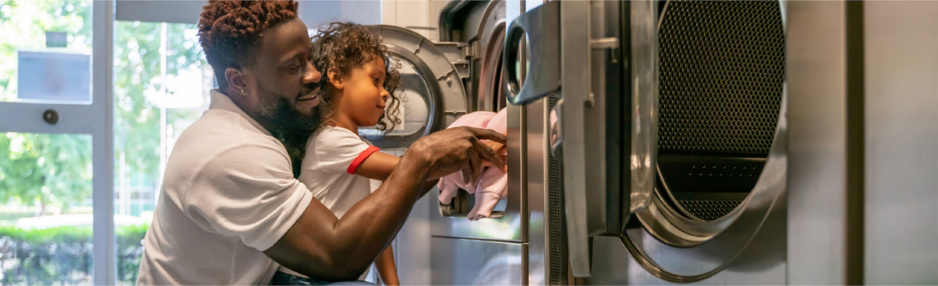 father and child doing laundry